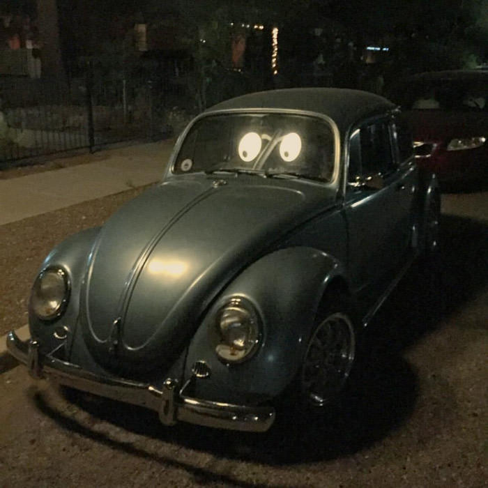 The reflection from the street lamps makes this VW bug look like it has cartoon eyes